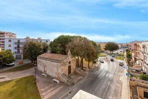 Une vue de rue avec un petit immeuble, une route et des immeubles résidentiels environnants.
