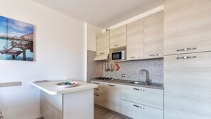 Uma cozinha moderna com micro-ondas, pia e armários de madeira.