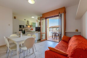 Un appartement moderne doté d’un coin repas, d’une cuisine et d’un balcon avec vue.