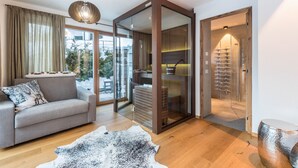 A modern living room with a sofa, a glass door leading to a balcony, and a wooden cabinet.