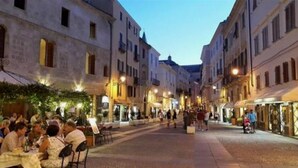 A street with buildings, outdoor seating, and people. - TOPAZ in OLD TOWN!  Romantic  near the sea! Alghero smart country style! Wi-Fi (Alghero)