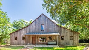 A rustic wooden barn with a porch, stone steps, and a clear blue sky in the background. - Ada's Whole House 3 Bedroom Apts by RedAwning (Fredericksburg)