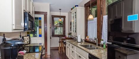 A kitchen with a granite countertop, stainless steel appliances, and wooden cabinets.