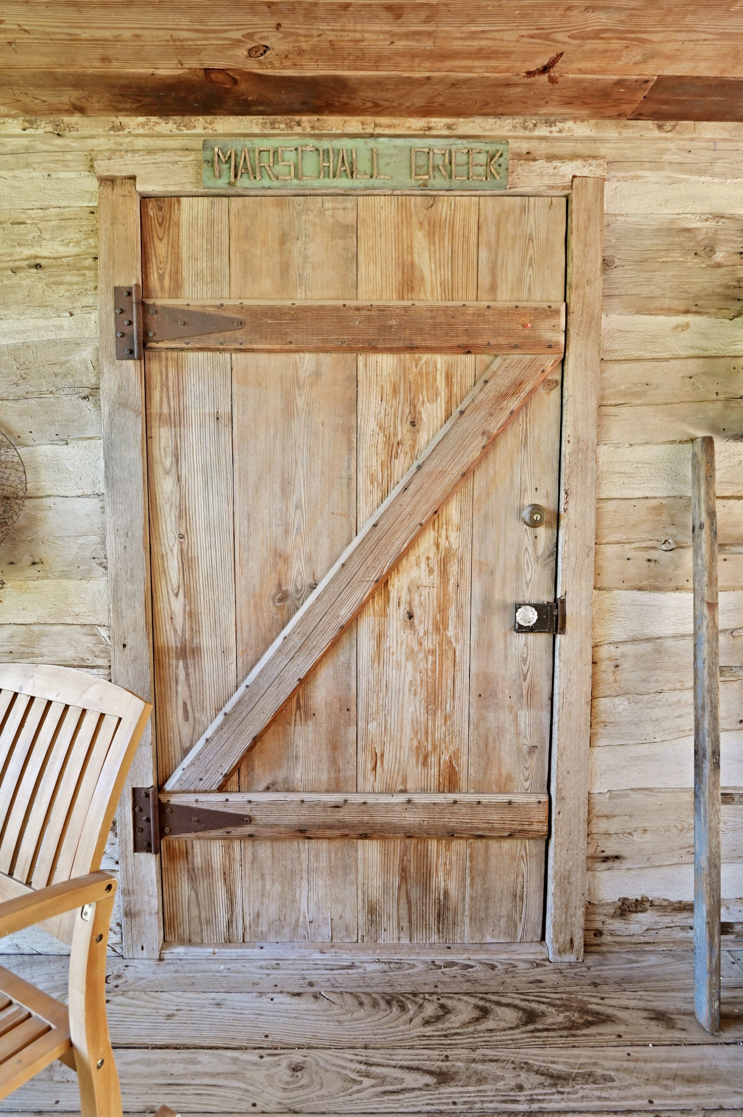 A wooden door with a metal latch and a sign above it that reads "MARSHAL'S ENERGET".