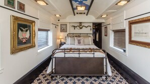 A bedroom with a large bed, a ceiling with a cloud design, and framed pictures on the walls. - 1894 Private Pullman Palace Ca 1 Bedroom Apts by Redawning (Fredericksburg)