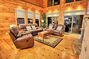 A wooden interior with a leather sofa set, a coffee table, and a Christmas tree. - Sky High in West Jefferson, NC: Spacious 4BR cabin for 10 with stunning mountain views. (West Jefferson)