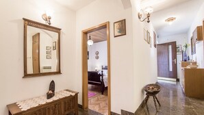 A hallway with a wooden bench, a mirror, and a small table with a bowl. - Holiday Home Villa Spilla (Selca)