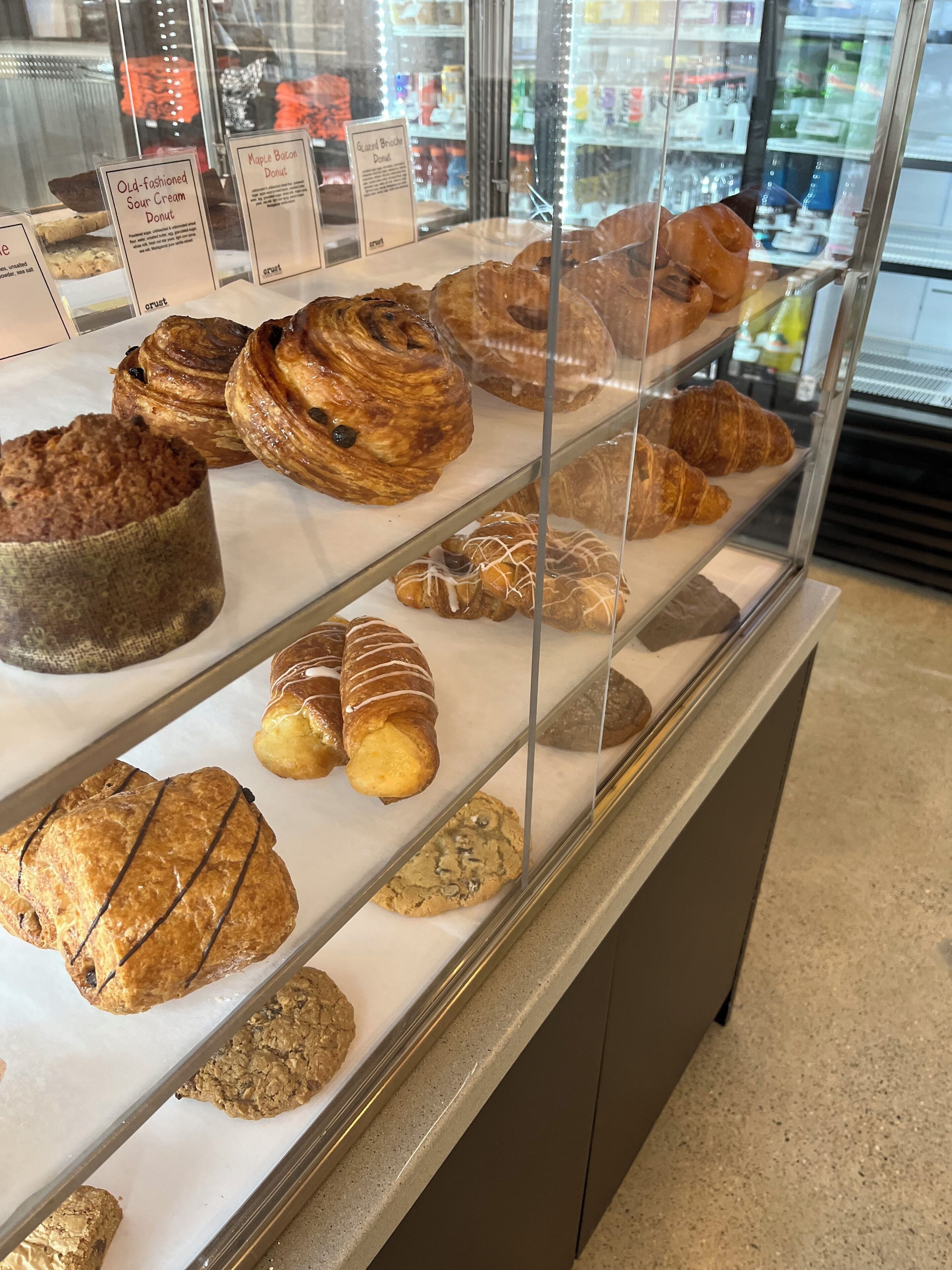 A bakery display case with various pastries and donuts.