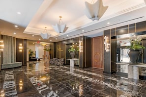 A modern lobby with marble flooring, contemporary lighting fixtures, and a reception desk. - Cambria Hotel Detroit Downtown (Detroit)
