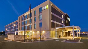 A multi-story hotel with a modern design, featuring a covered entrance and a stone facade. - Home2 Suites by Hilton Tucson Airport (Tucson)