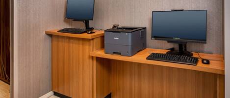 Una mesa de recepción con dos monitores, un teclado y una impresora.