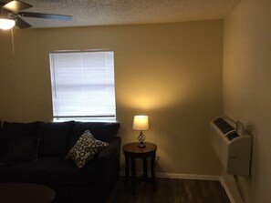 A living room with a couch, a lamp, a small table, and a ceiling fan. - Simple 1-bedroom unit upstairs close to Fort Sill! (Lawton)