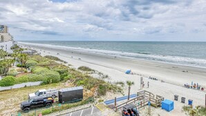 Una playa con un estacionamiento, un camión y un edificio al fondo.