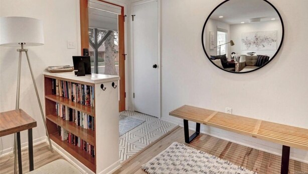 A hallway with a bookshelf, a round mirror, and a bench. - Light + Bright Boulder Midcentury 30+ day rental  (Boulder)