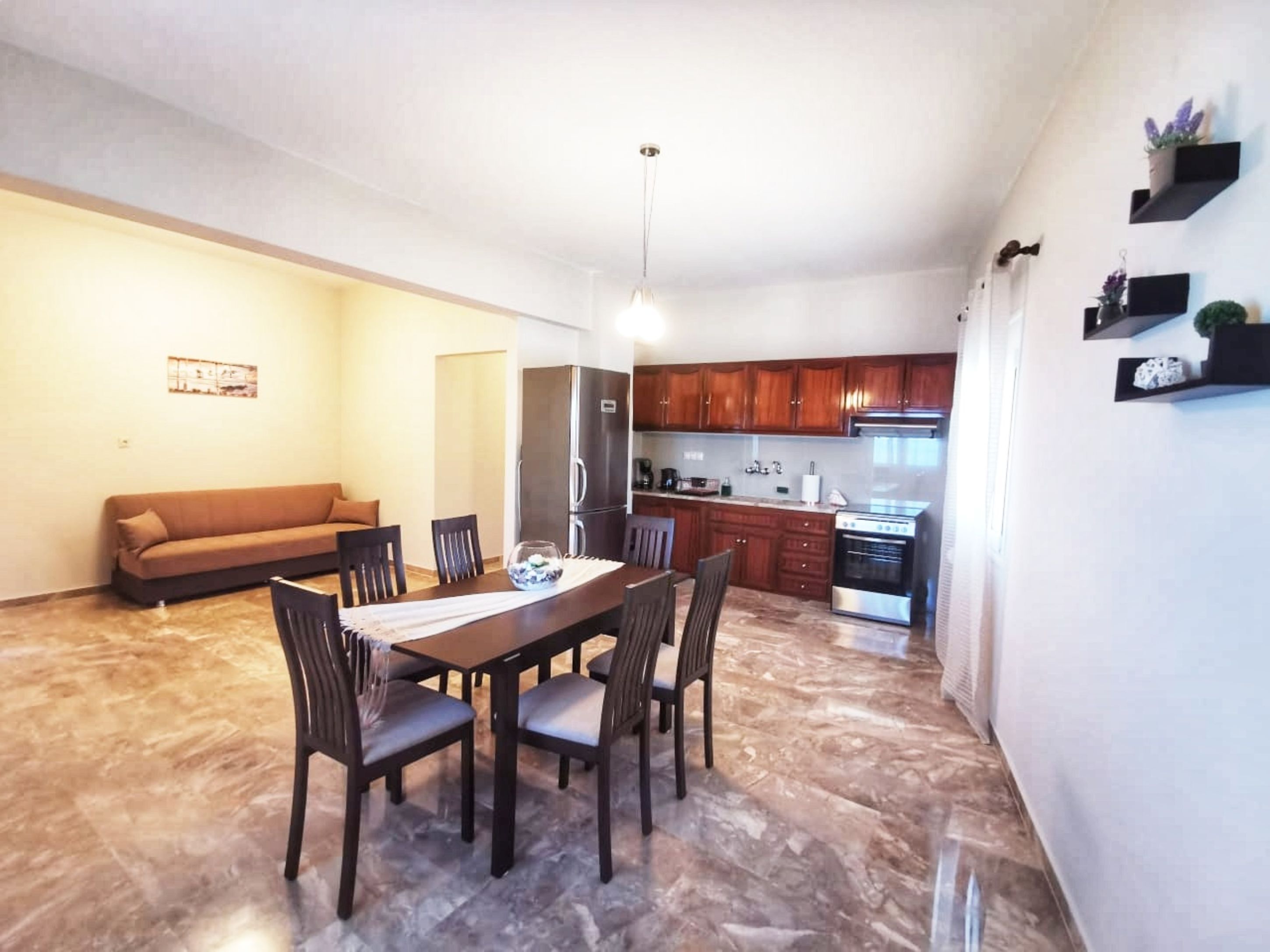A compact living space with a dining area, kitchenette, and a sofa.