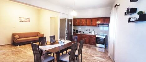 A compact living space with a dining area, kitchenette, and a sofa.