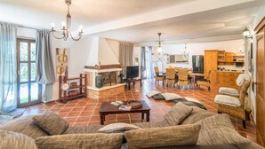 Una sala de estar con chimenea, un comedor y una cocina.