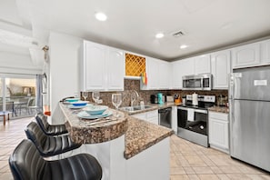 Enjoy cooking in this well-lit kitchen with a central island, stainless steel appliances, and granite countertop.