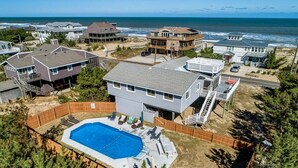 A residential area with houses, a swimming pool, and a view of the ocean.