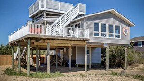 A two-story house with a balcony, a covered porch, and a sign indicating a restaurant.