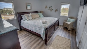 A bedroom with a bed, a chair, a ceiling fan, and a window. - Oceanview, Private Pool, Sleeps 16, Dogs okay, close to beach, PICKLEBALL COURT! (Virginia Beach)
