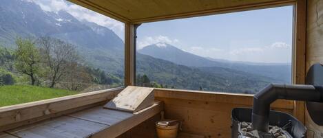 A wooden cabin with a wooden bench and a Harvia wood stove.