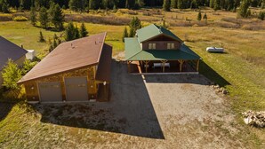 Une cabane avec un toit végétalisé, une véranda et une allée gravillonnée.