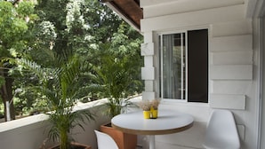 A balcony with a round table, two white chairs, and potted plants. - Apto muy bien ubicado Home ARIS 402 (Medellín)
