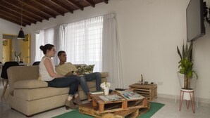 A living room with a sofa, a coffee table, and a potted plant. - Apto muy bien ubicado Home ARIS 402 (Medellín)