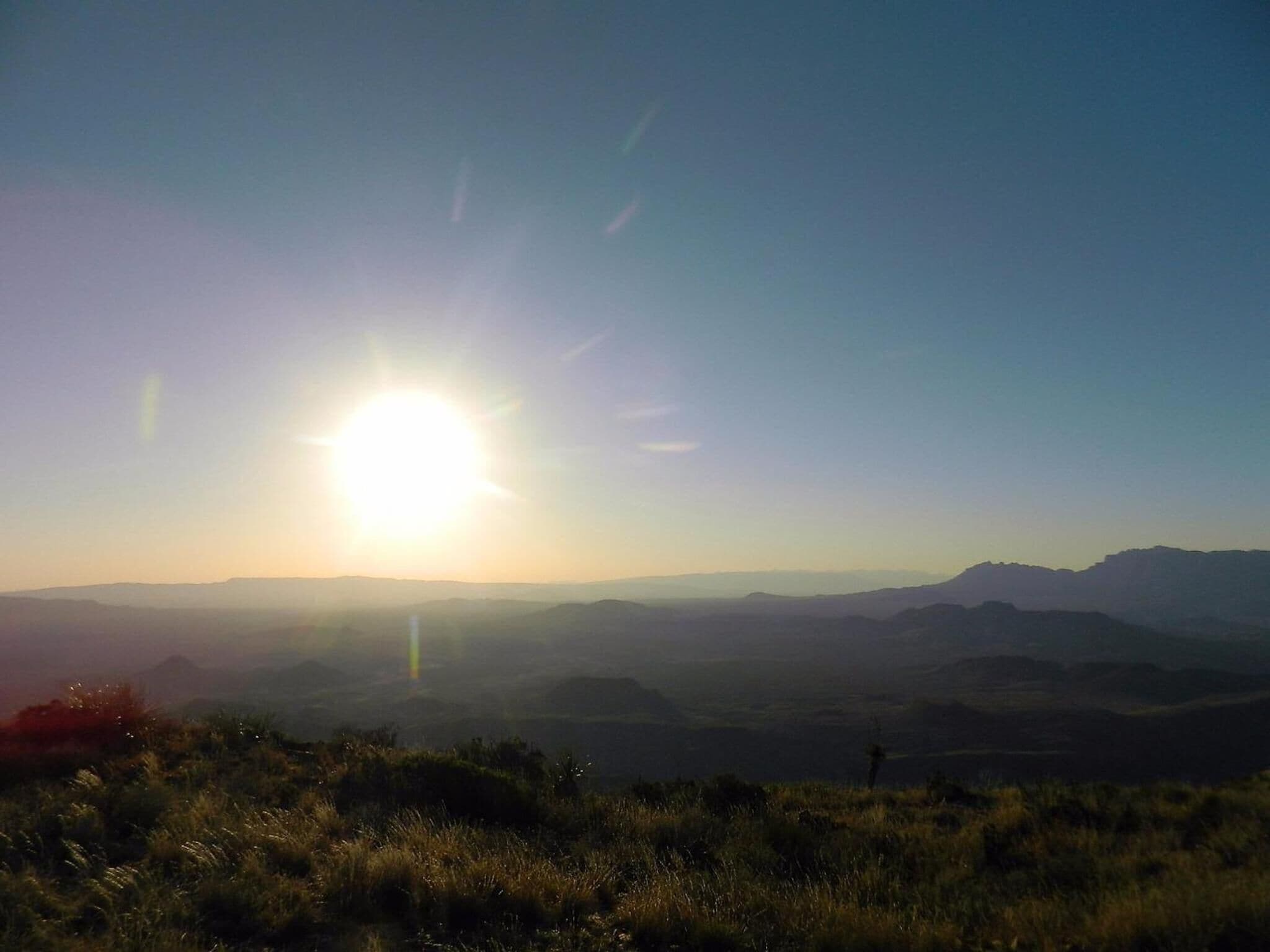 A landscape with a clear sky and distant mountains.