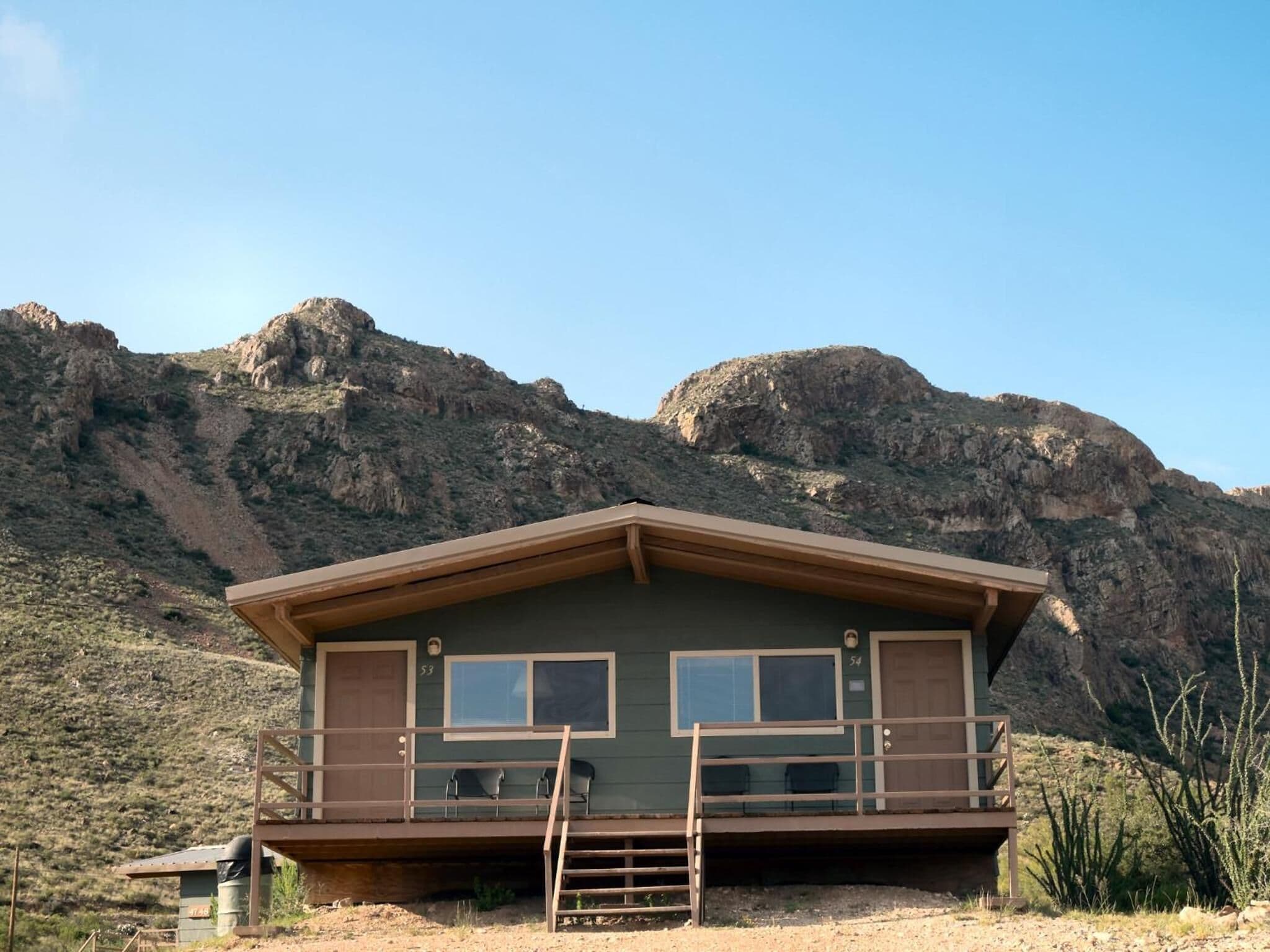 Una cabana amb un balcó, dues finestres i una porta.