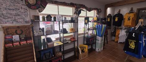 Ein Geschäft mit Regalen voller Hüte, Taschen und Kleidung.