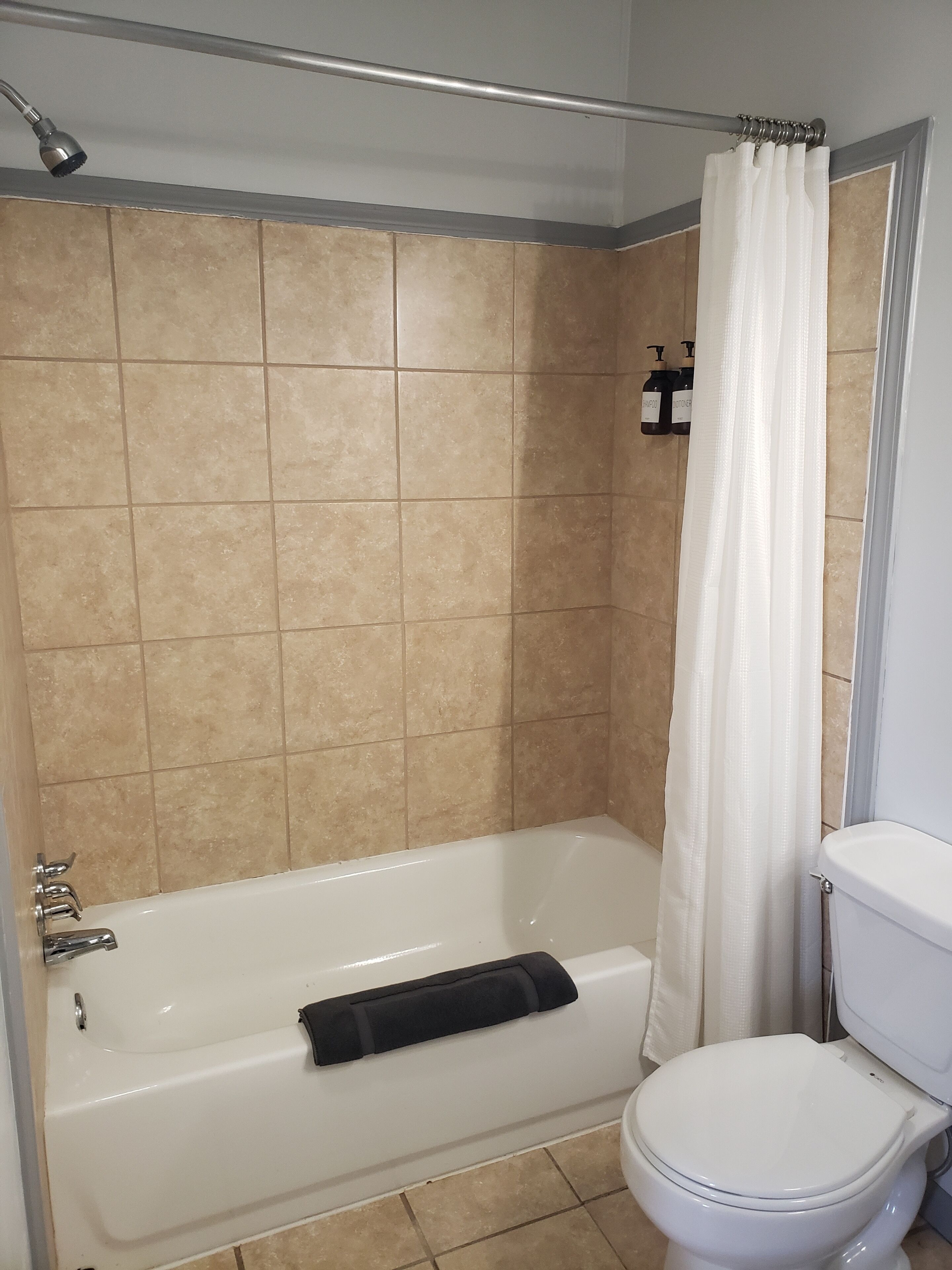 Ein Badezimmer mit Badewanne, Toilette und Duschvorhang.