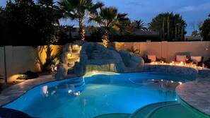 A swimming pool with a rock feature and seating area. - Scottsdale McCormick Ranch Oasis – Heated Pool, Slide, Spa – Walk to Restaurants (Scottsdale)