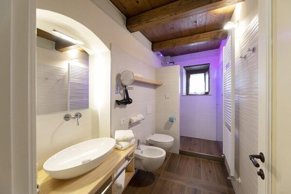 A bathroom with a wooden ceiling, a white sink, a toilet, and a bidet. - Antica Torre Del Nera (Scheggino)