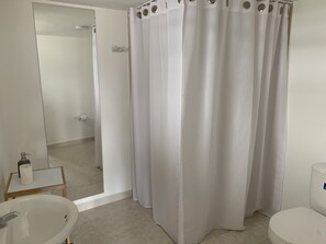 Departamento urbano | Baño | Regadera, regadera tipo lluvia, toallas, papel de baño 
