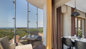 En balkon med et spisebord dækket til to, med udsigt over et smukt landskab.