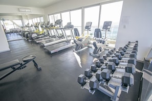 A gym with treadmills, elliptical machines, and dumbbells. - Beautiful Malecon and Beyond 1502 Torre eMe (Mazatlan)