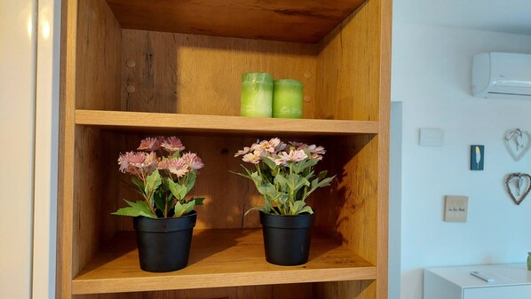A wooden shelf with two black pots containing pink flowers. - Villa Ernesta with Pool (Pula)