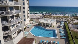 A hotel with a swimming pool, beach view, and multiple balconies. - Gulf View, Updated Condo, Steps from the ocean, Short Drive to Shopping (Destin)