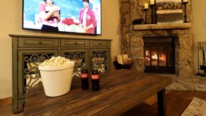 A living room with a television, popcorn, and Coca-Cola bottles on a wooden table.
