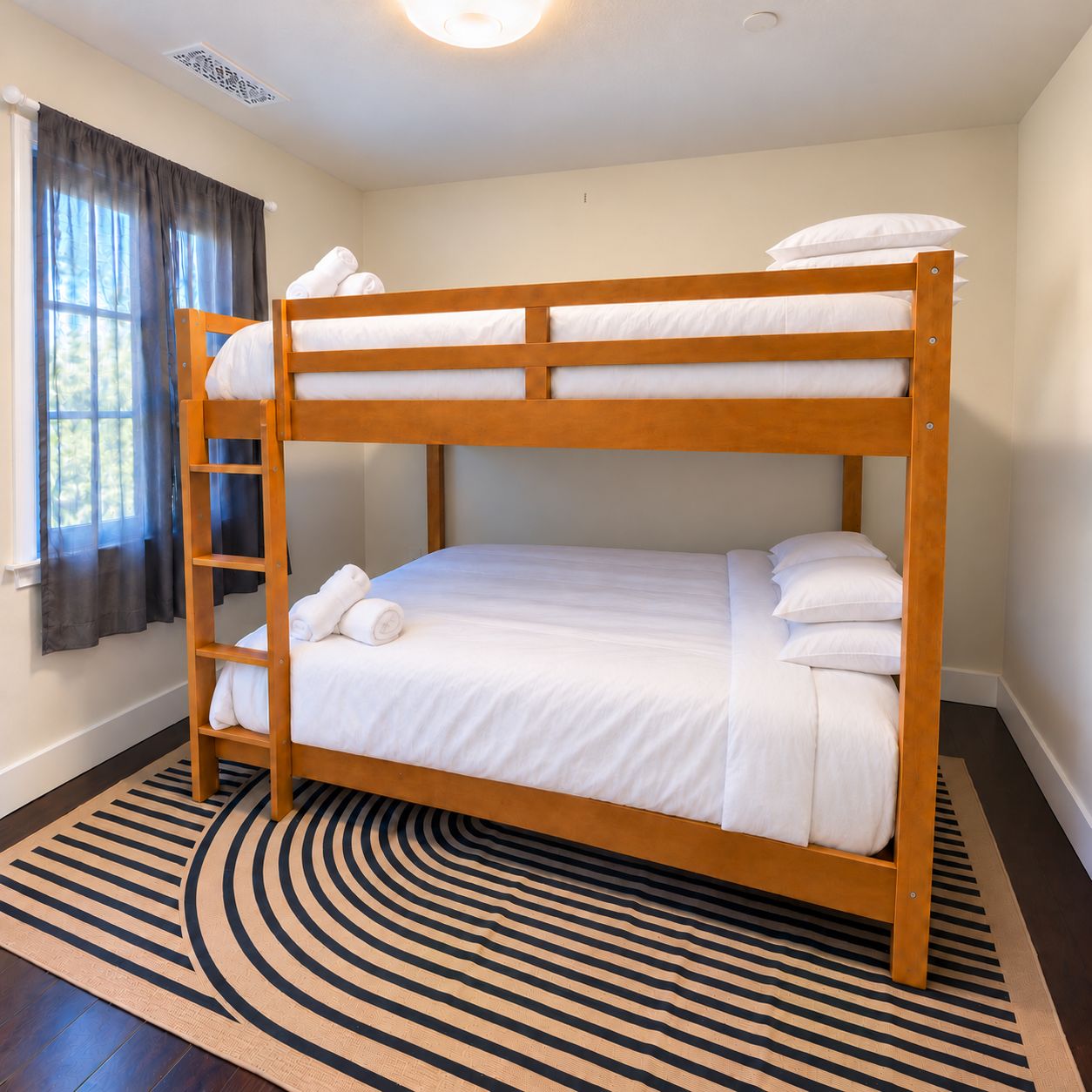 A bunk bed with white bedding, a wooden ladder, and a striped rug.