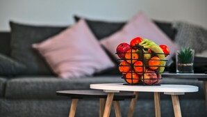 A fruit basket on a small table in front of a sofa with cushions. - LA LOVE LIFE (Mulhouse)