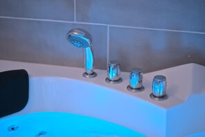 Ein Badezimmer mit einer Badewanne, einer Dusche und zwei Wasserhähnen.
