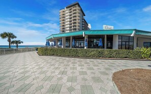 Ein Hotel direkt am Strand mit modernem Design, das ein markantes Gebäude mit Balkonen und einem Schild mit der Aufschrift "Oceans" zeigt.