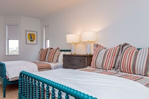 A hotel room with two beds, a nightstand, a lamp, and a framed picture on the wall. - Pool/Spa | 14 Beds | Sleeps 28 - WalkerVR Sundown Escape (Austin)