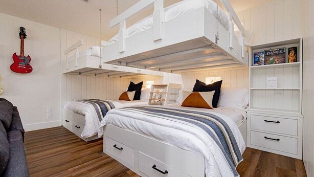 A bunk bed room with a guitar, a bookshelf, and a desk. - Pool/Spa | 14 Beds | Sleeps 28 - WalkerVR Sundown Escape (Austin)
