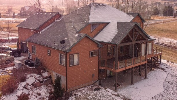A large, two-story house with a prominent front porch and a garage.