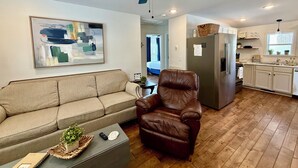 A living room with a sofa, a leather chair, a coffee table, and a ceiling fan. - Lil Gem - near Bethel and HCMC (Paris)