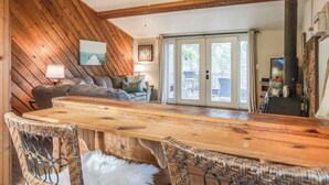 Ein rustikales Interieur mit einem Holzesstisch, Korbstühlen und einem Deckenventilator.